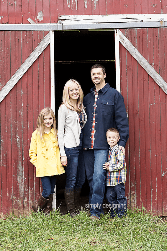 Family Photo of parents Standing in front of partially opened Barn Door with kids on the sides in front of barn doors