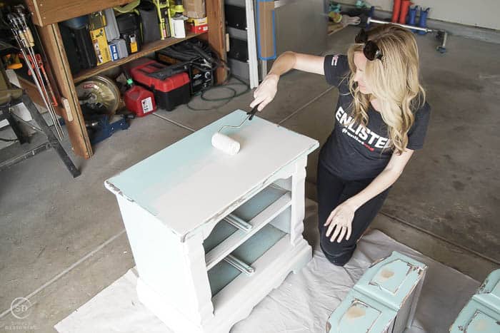 Use a roller brush to paint the larger portions of a bedside table