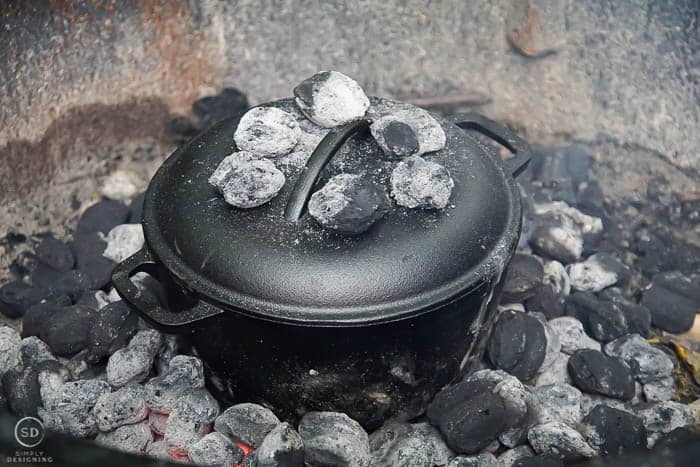 charcoals around and on top of dutch oven for cobbler