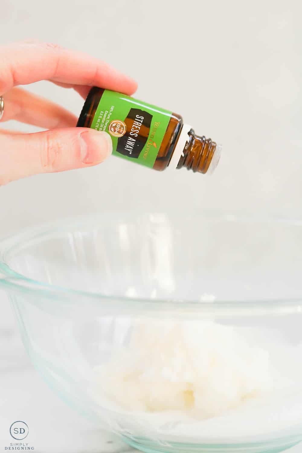 dropping stress away essential oil into glass bowl with sugar and coconut oil
