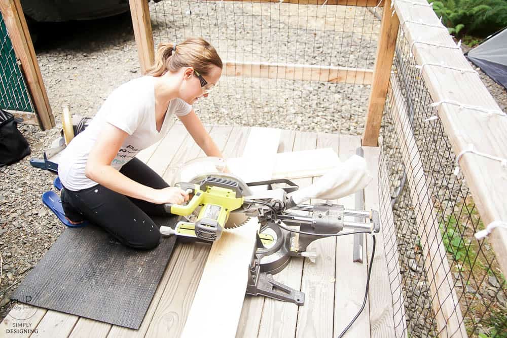 woman cutting wood with a compound miter saw
