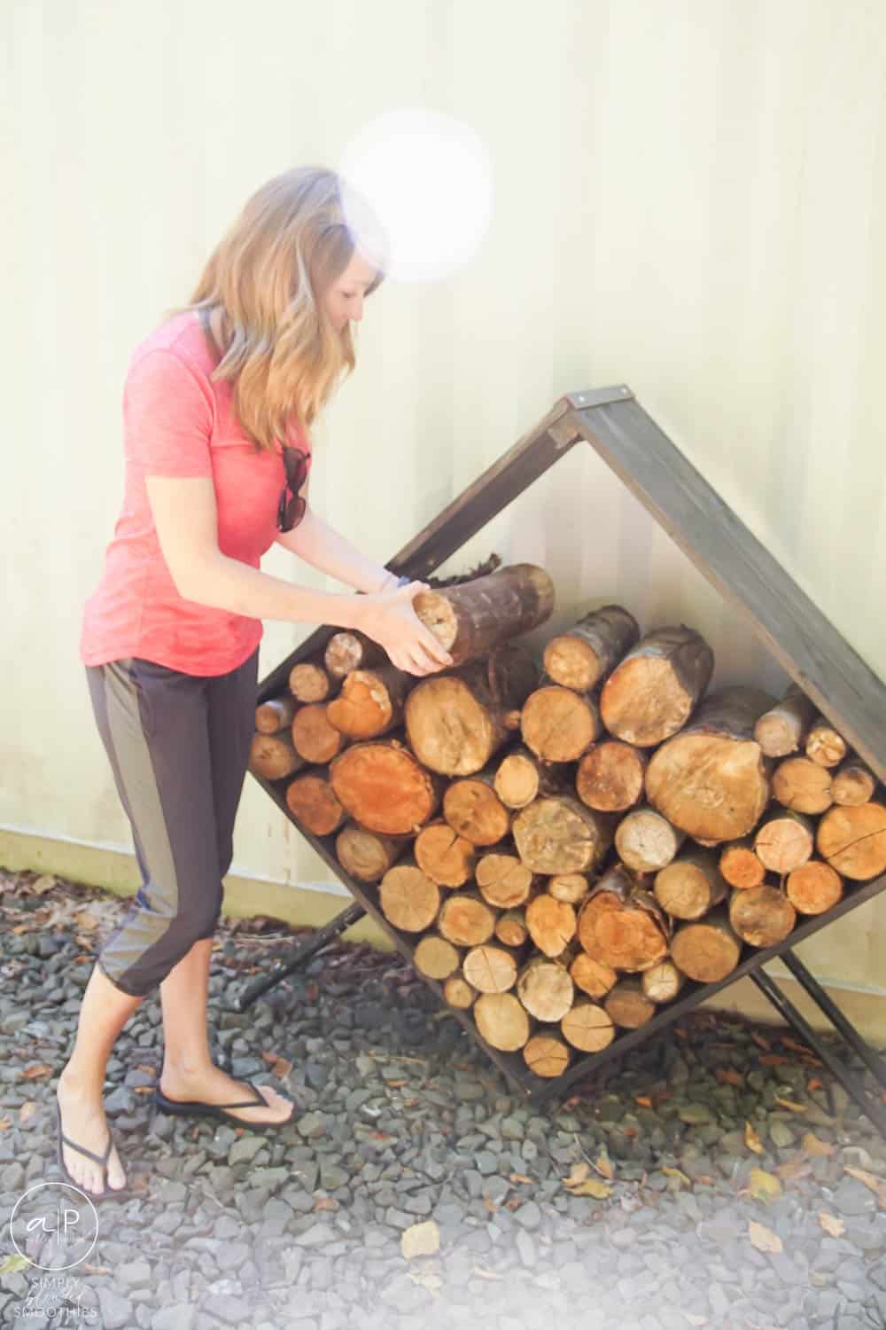 woman placing firewood in a modern holder