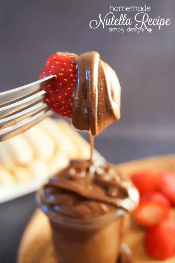 Strawberry on a fork dripping with chocolate and hazelnut homemade Nutella